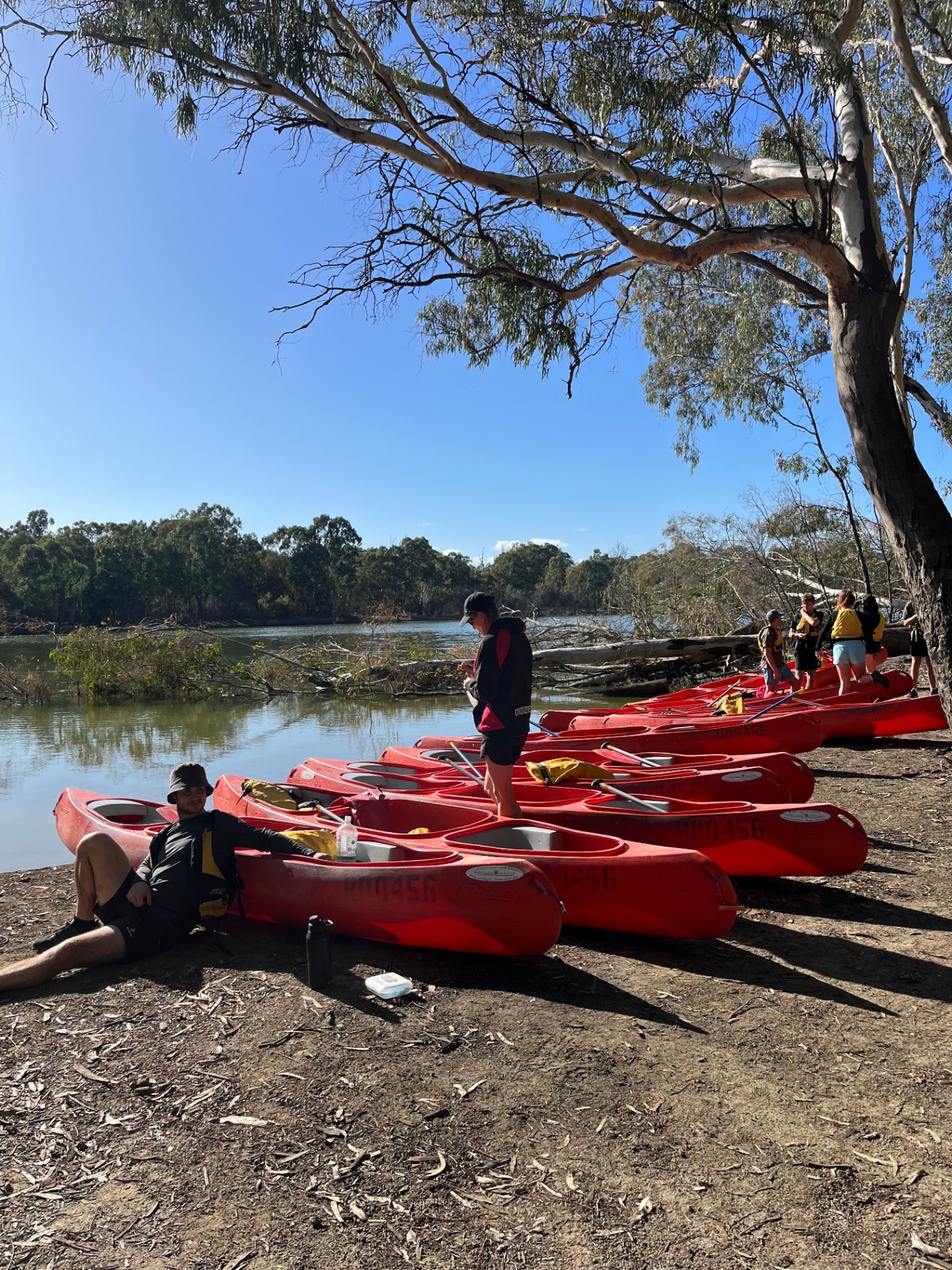 Wildside Outdoors crew with red kayaks on the Murray River bank